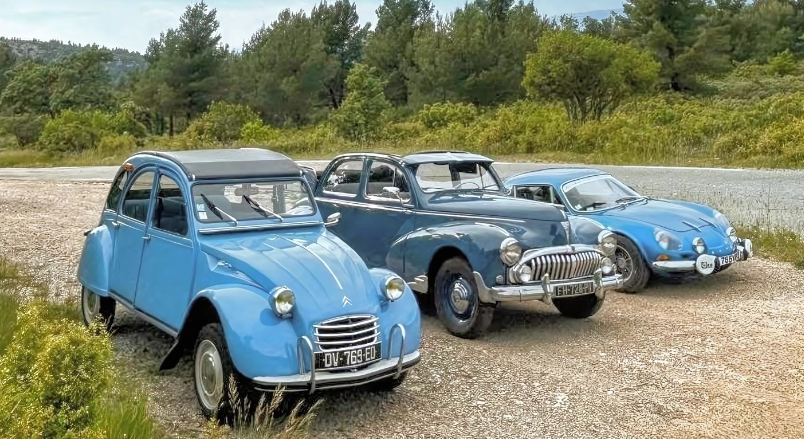 Trois voitures de collection bleu pastel garées en extérieur pour une animation rétro